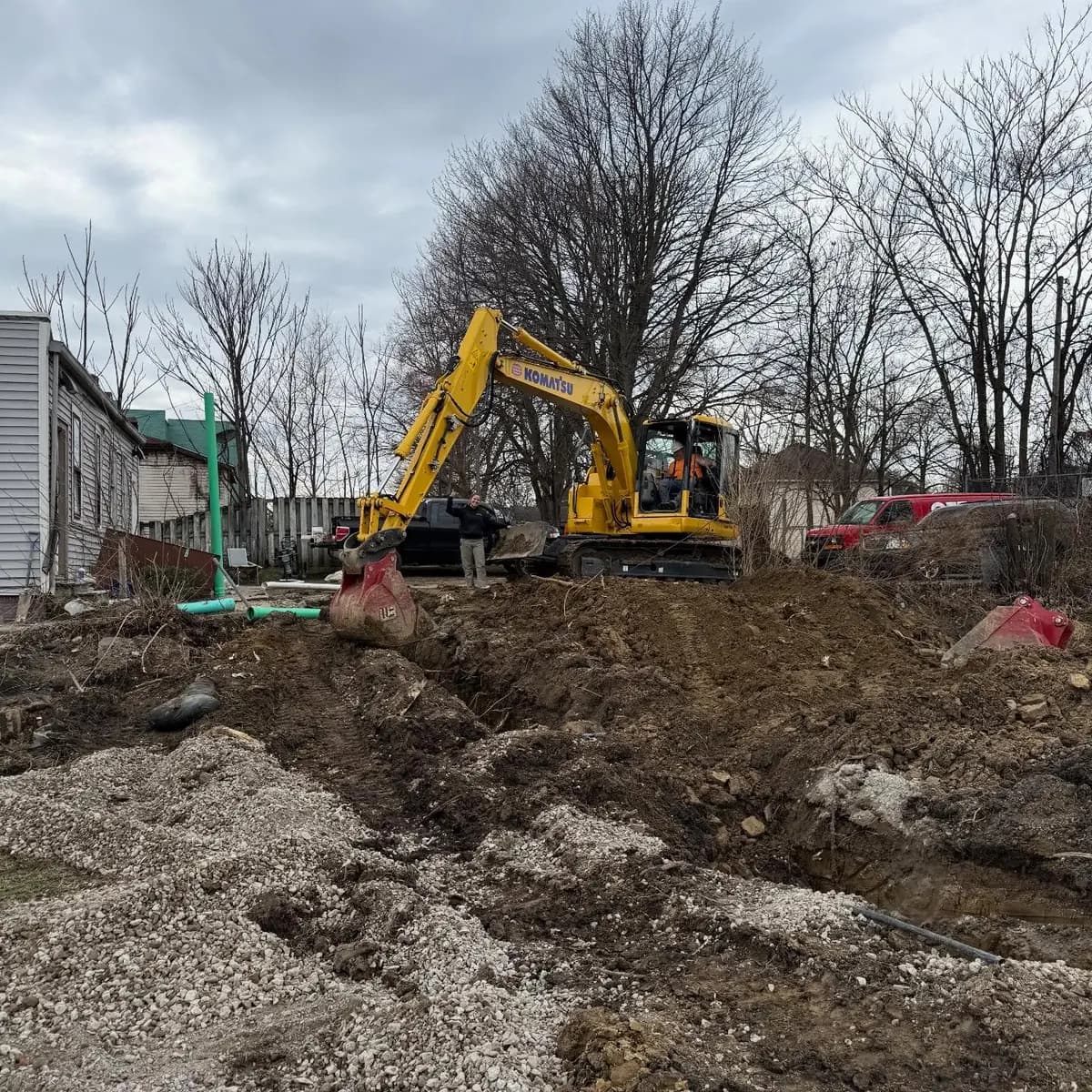 Yellow excavator working at an established residential property